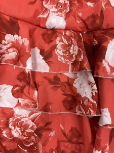 Vue détaillée de volants à imprimé floral rouge avec des surpiqûres blanches fines
