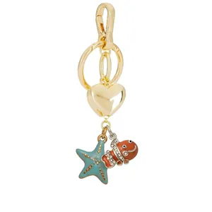 Close-up detail of ocean theme bag charm featuring enamel clownfish and starfish charms.