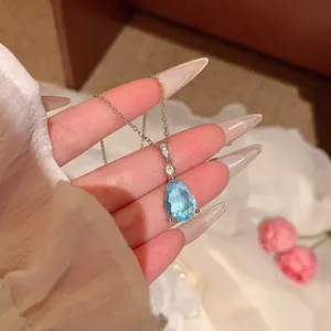 Detailed macro view of a light blue teardrop crystal pendant necklace on silver chain