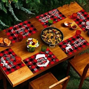 Festive red plaid Christmas placemats set on a wooden table with dining accessories.