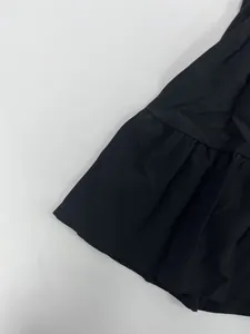 Gros plan sur l'ourlet à volants et la texture du tissu d'une robe noire élégante