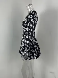 Vue latérale d'une élégante robe courte à fleurs noires avec col en V et manches bouffantes
