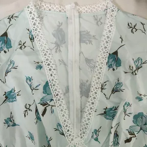 Vue détaillée de l'encolure en dentelle blanche et du zip sur une robe fleurie
