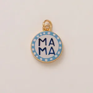 Détail d'un pendentif en acier doré avec texte MAMA sur fond bleu à pois blancs