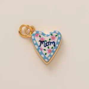 Gros plan d'un pendentif en cœur avec motif floral 'Mom' et placage en or 18 carats