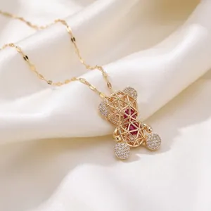 Élégant collier pendentif ours évidé en or avec pierres rouges sur soie blanche