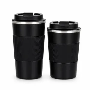 Dettaglio di due tazze da caffè termiche in acciaio inox nero su sfondo bianco