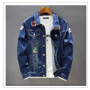 Detailed look at a men's blue denim jacket featuring multiple embroidered patches