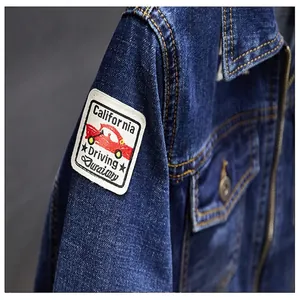 Detail view of denim jacket sleeve with vintage car embroidered patch