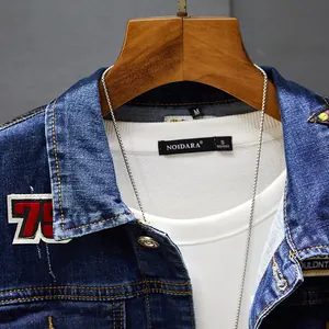 Detail of men's slim fit blue denim jacket featuring vintage embroidered patches