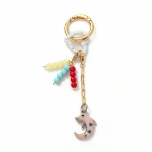 Vue détaillée d'un bijou de sac perlé avec pendentif dauphin rose et motifs cœurs