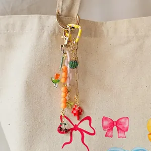 Gros plan d'un bijou de sac DIY coloré avec pendentifs cerise et cœur sur un sac en toile