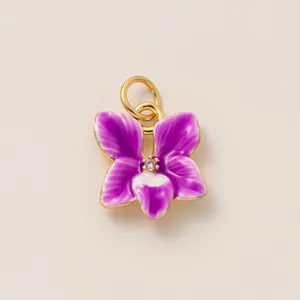 Vue détaillée d'une breloque orchidée en émail violet avec base en cuivre doré pour bijoux