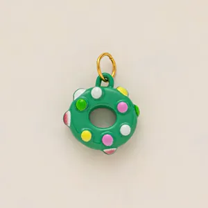 Vue détaillée d'un charm de donut vert avec des pois colorés pour un porte-clés DIY