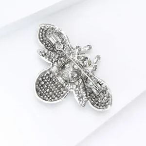 Detail view of silver-tone alloy bee brooch back with secure pin clasp mechanism