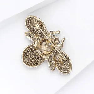 Close-up of the back of a vintage gold alloy bee brooch with a safety pin clasp