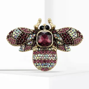 Vintage bee brooch with purple gemstone and iridescent rhinestones in antique gold