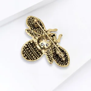 Detail view of bee brooch back showing antique gold finish and secure pin fastener