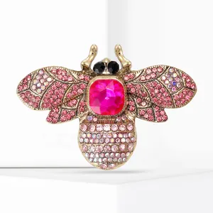 Close-up of pink gemstone and rhinestone details on ornate bee brooch