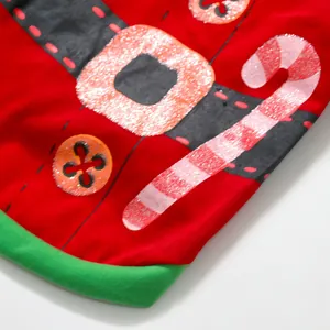 Close-up detail of Christmas dog costume showing candy cane and festive belt print
