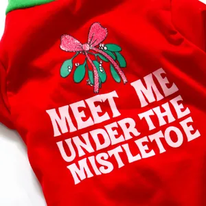 Close-up of a festive red Christmas dog t-shirt with 'Meet Me Under The Mistletoe' text