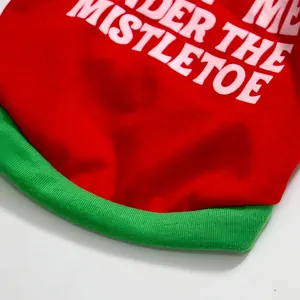 Close-up of Christmas dog t-shirt with red fabric, green trim and mistletoe print.