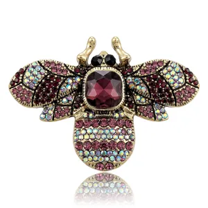 Antique gold bee brooch with purple rhinestones and central crystal