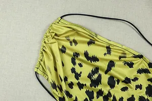 High-quality close-up detail of a yellow leopard print pleated dress with sleek fabric texture