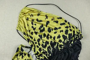 Close-up detail of yellow and black leopard print ruched dress fabric with thin straps