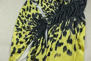 Detailed view of ruched fabric with yellow and black abstract leopard print texture.