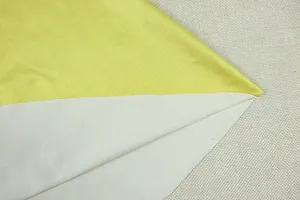 Macro view of lime green and light gray fabric texture for color-blocked pleated mini dress
