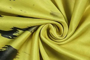 Detailed macro shot of yellow fabric with black abstract print showing woven texture