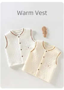 Détail de deux gilets matelassés pour bébé en blanc et beige avec broderie ours