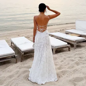 Close-up detail of a white lace backless maxi dress featuring elegant criss-cross back straps
