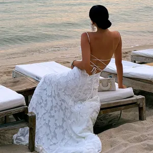 Detailed back view of a white lace backless dress with spaghetti straps and cross-ties