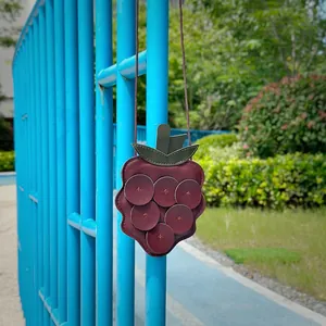 Detail view of the cute raspberry-shaped soft litchi grain leather bag for kids.