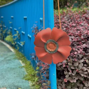 Detail view of a cute orange flower-shaped kids bag in soft lychee grain leather.