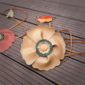 Close-up of soft lychee-textured leather poppy flower crossbody bag for kids