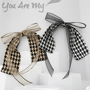 Close-up of elegant houndstooth and dotted fabric hair ties with layered organza bows