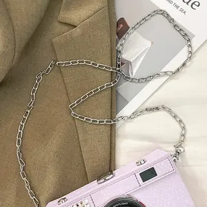 Detailed macro view of the vintage purple camera hard box bag with a silver chain strap