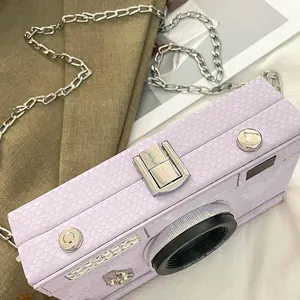Close-up of retro camera-shaped purple crossbody bag with snakeskin texture