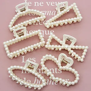 Close-up detail of elegant white pearl-studded hair claw clips in five geometric shapes