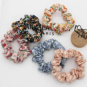 Detailed view of assorted floral print cloth scrunchies in various spring colors.