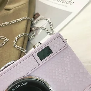 Close-up detail of lilac snake pattern vintage camera shaped crossbody box bag
