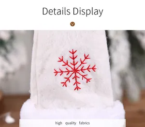 Detallado primer plano de bordado de copo de nieve rojo en funda de botella blanca