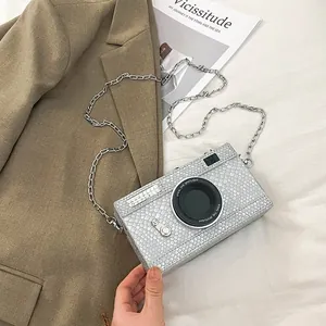 Detail view of a vintage silver camera-shaped hard box bag with metallic chain strap