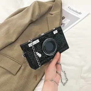Close-up of a vintage camera-shaped box bag with black snakeskin texture and chain strap