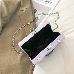 Detailed view of the open purple vintage camera box bag with black lining and silver chain