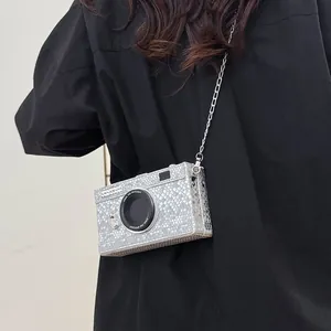 Detail of vintage camera-shaped crossbody bag with silver snakeskin texture worn on back