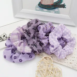 Detailed macro view of a 4-pack of purple floral and plaid fabric hair scrunchies.